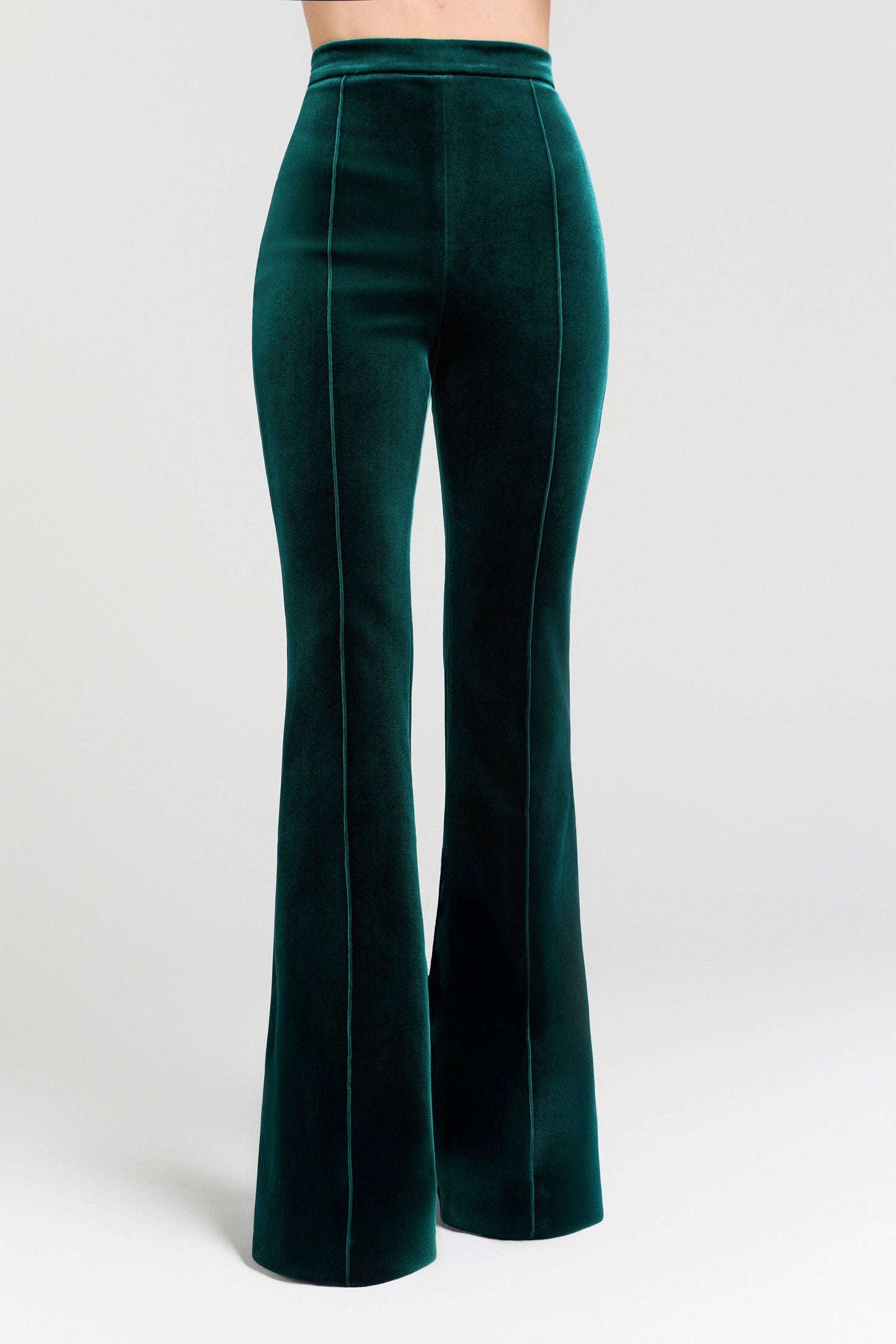 Green velvet flared pants on a white background