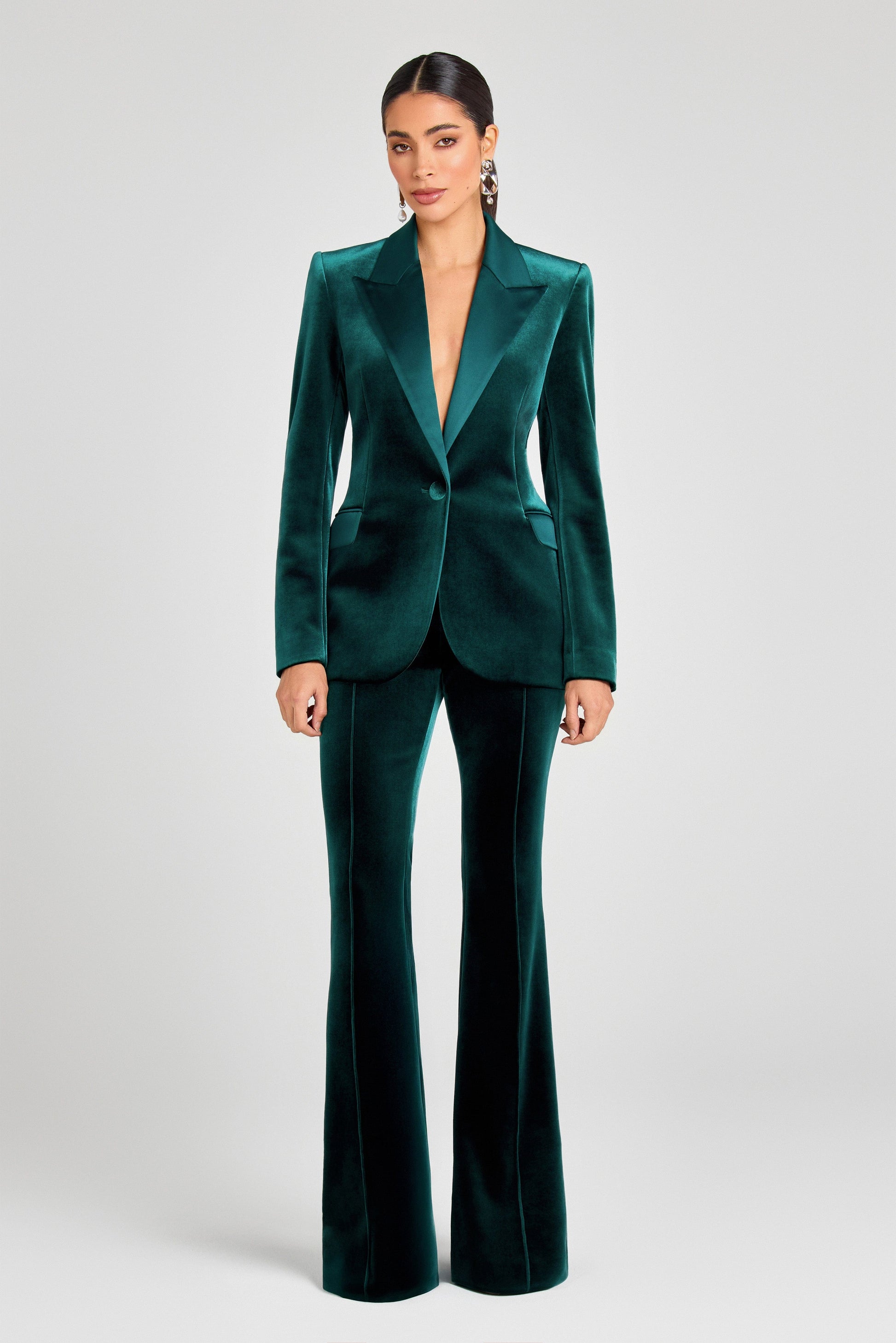 Woman wearing a green velvet suit on a white background