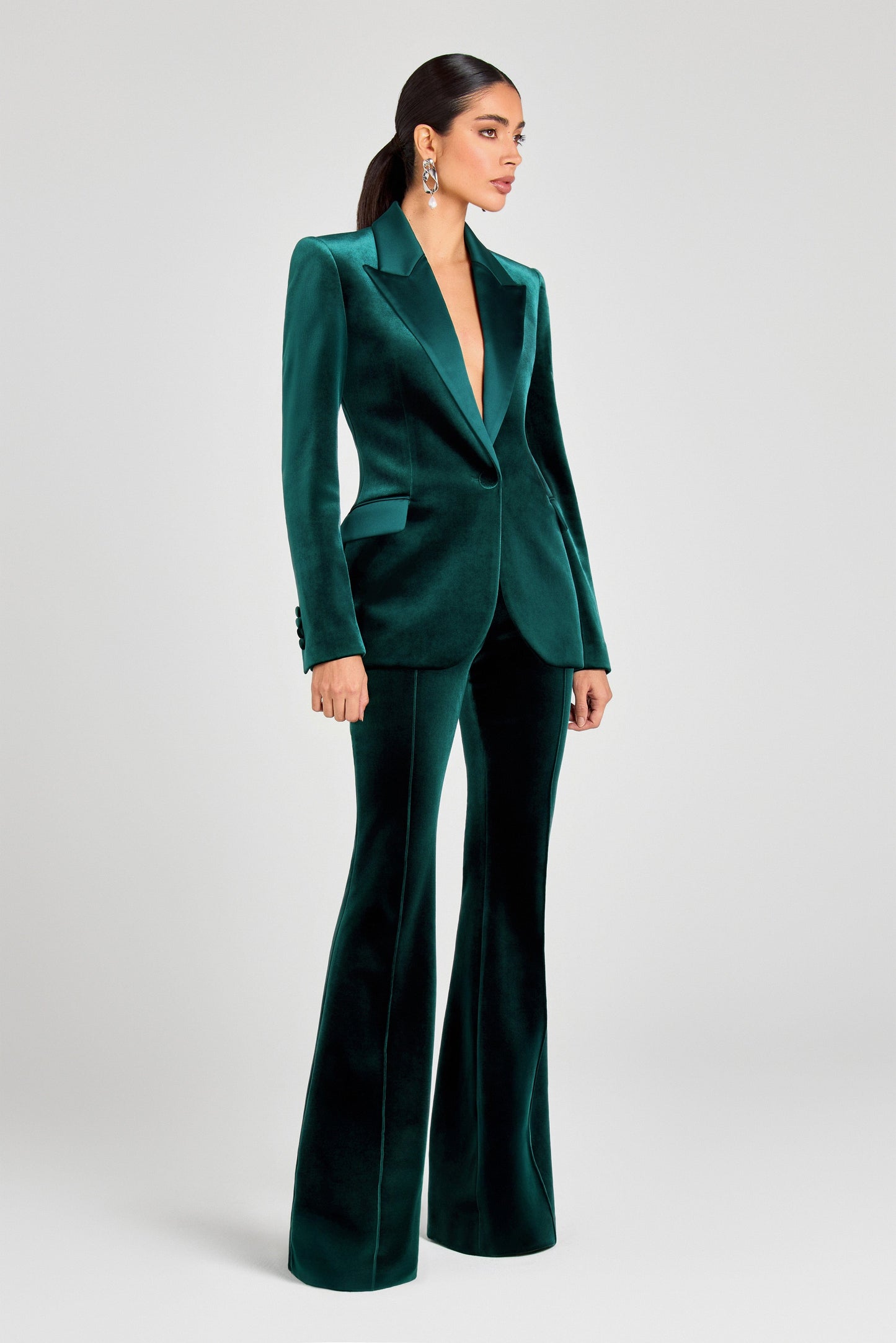 Woman wearing a green velvet suit on a white background