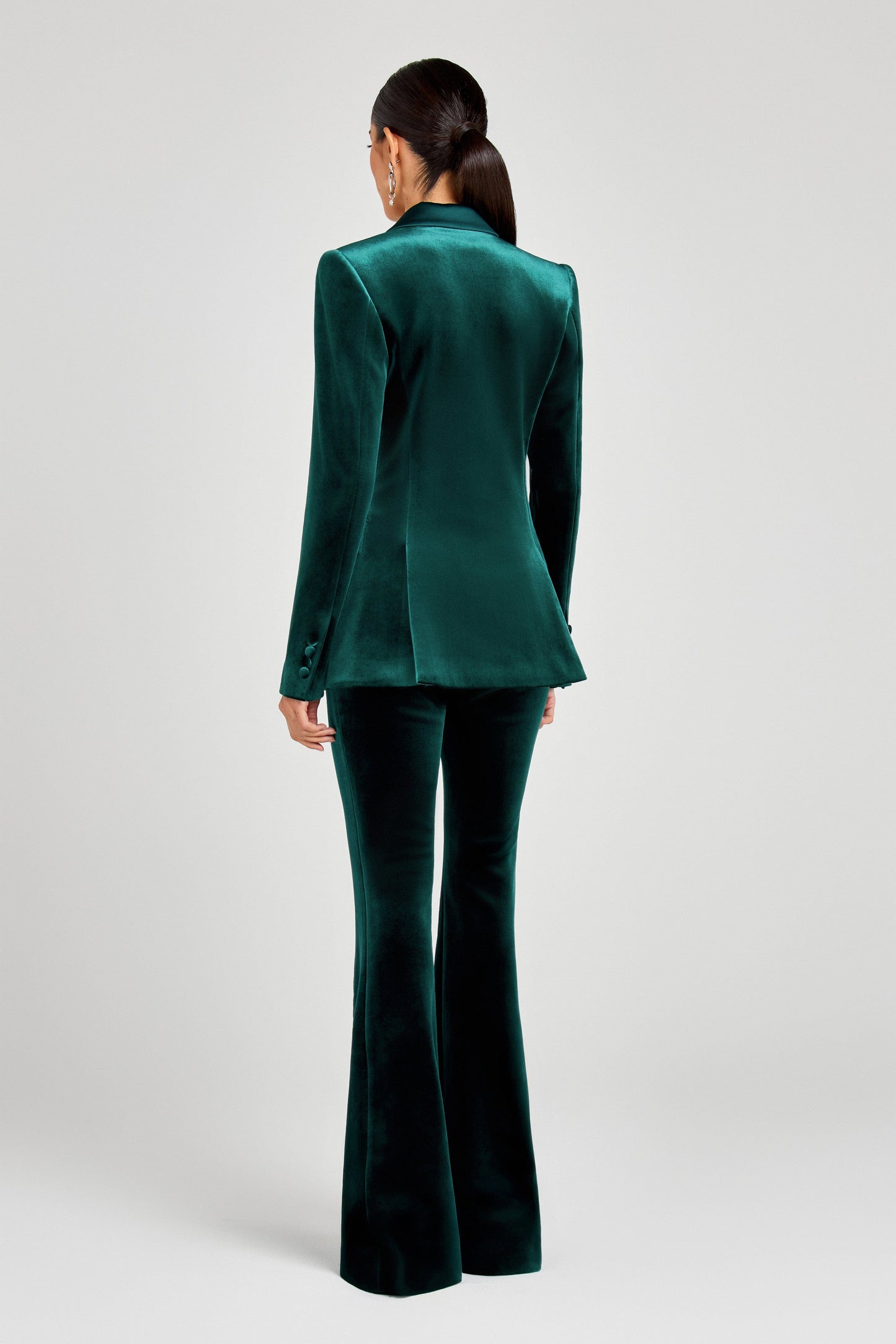 Green velvet suit with high-waisted pants on a white background
