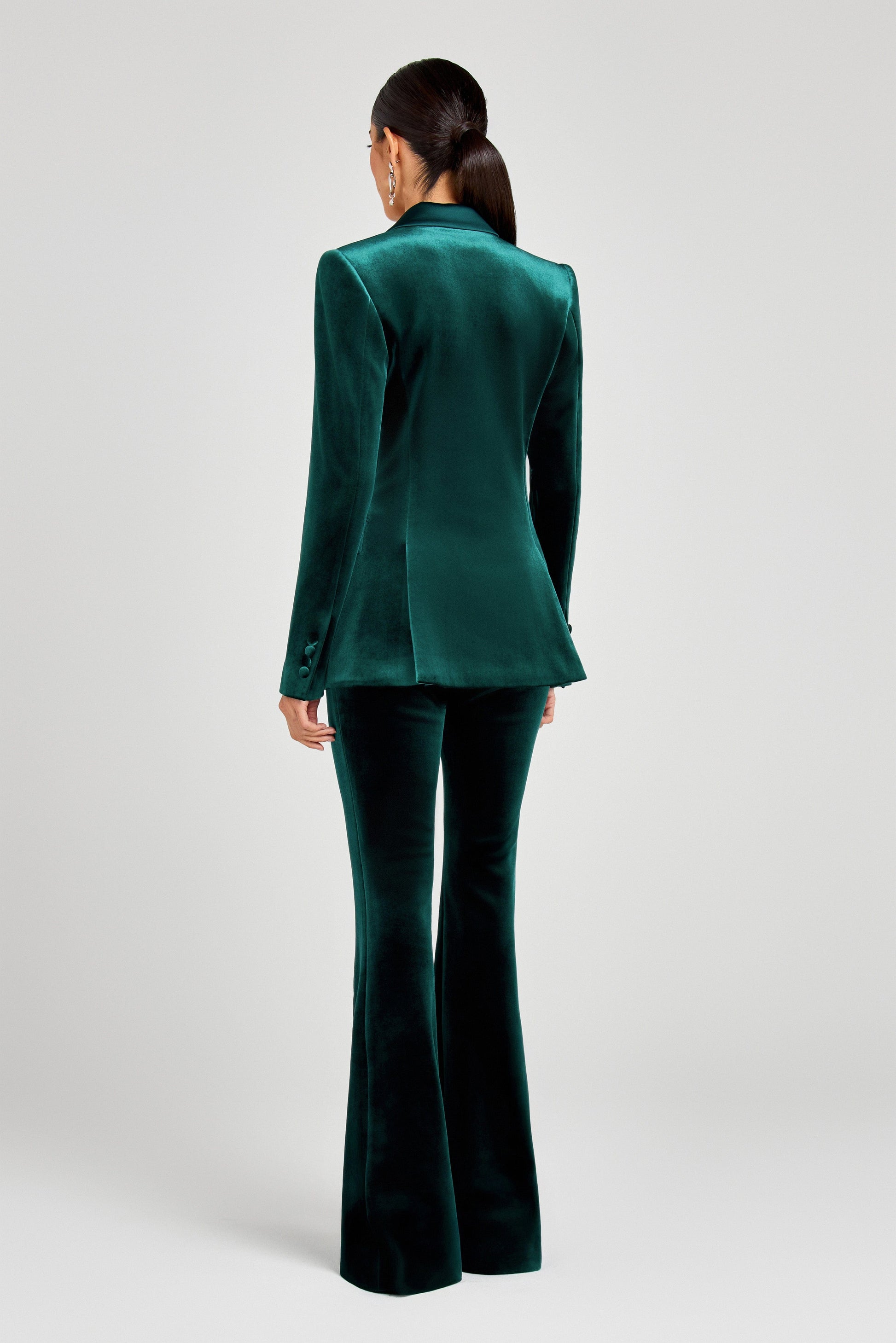 Green velvet suit with high-waisted pants on a white background