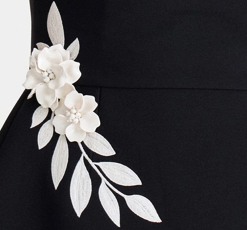 White floral and leaf embellishment on a black background
